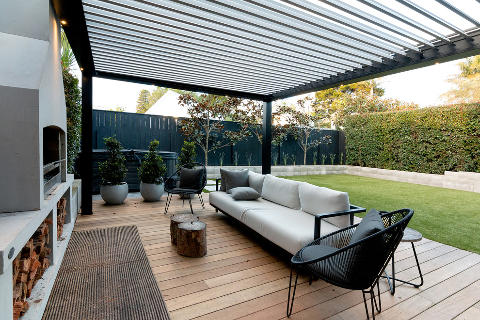 Inspiration pour une grande terrasse arrière design avec une cuisine d'été et une extension de toiture.