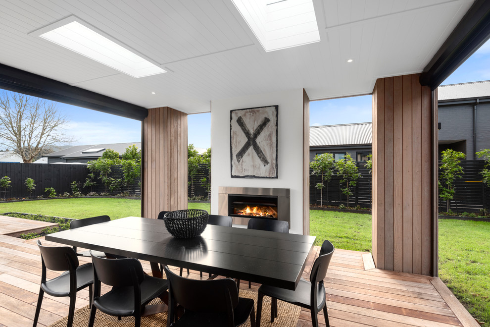 Photo of a contemporary terrace in Auckland with a fireplace and a roof extension.