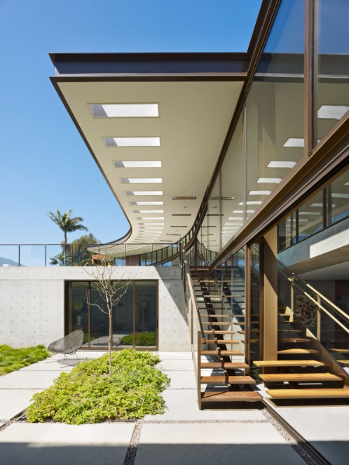 Idée de décoration pour une très grande terrasse arrière minimaliste avec une extension de toiture.