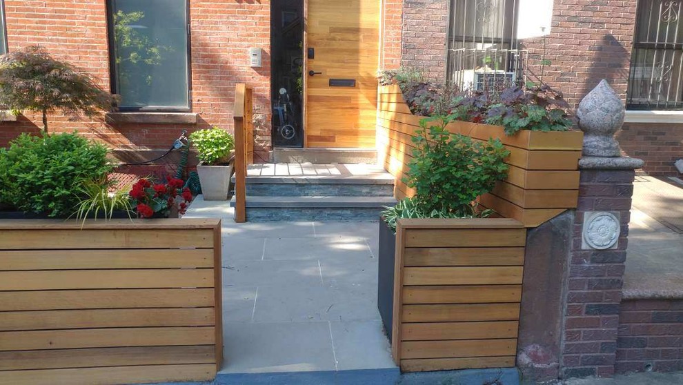 This is an example of a medium sized modern back terrace in New York with a potted garden and no cover.