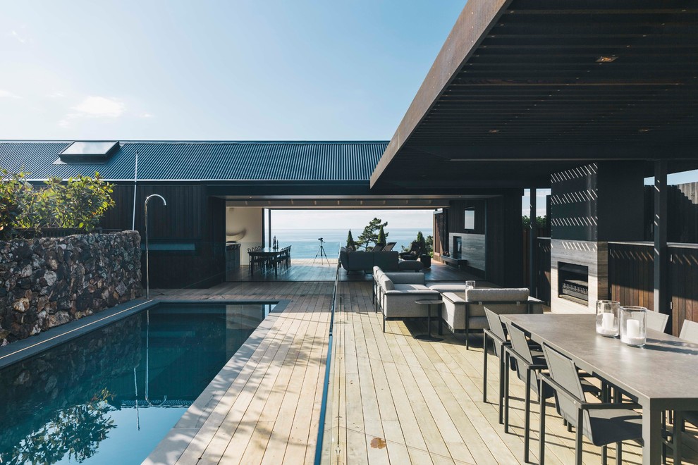 Inspiration for a contemporary deck remodel in Auckland with a fire pit and a pergola
