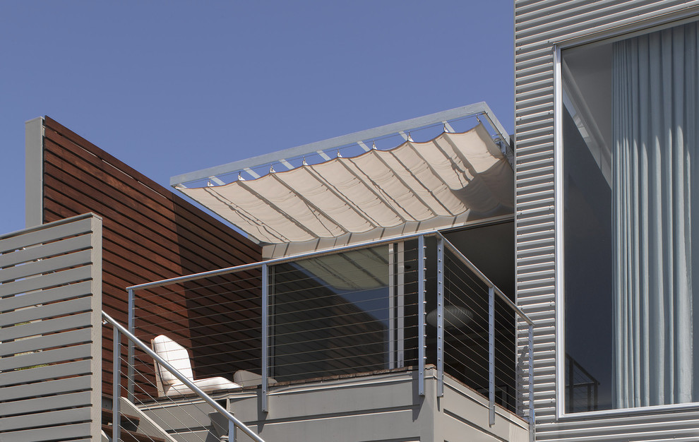 Réalisation d'une terrasse arrière design de taille moyenne avec un auvent.