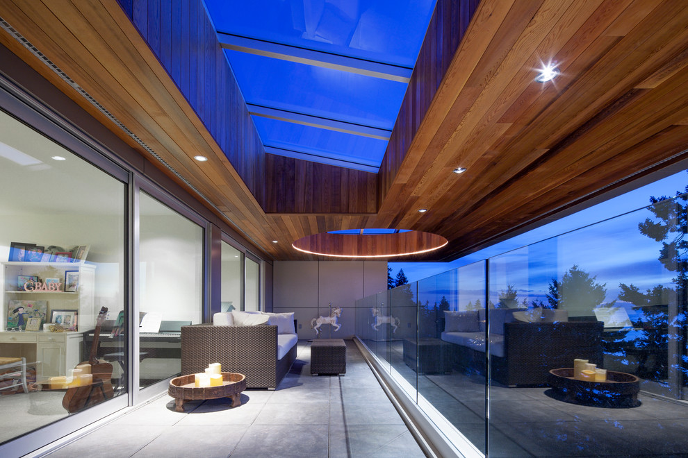 Inspiration pour une terrasse design avec une extension de toiture.