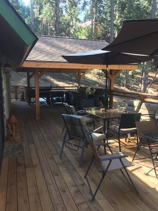 Exemple d'une grande terrasse arrière chic avec une cuisine d'été et une extension de toiture.