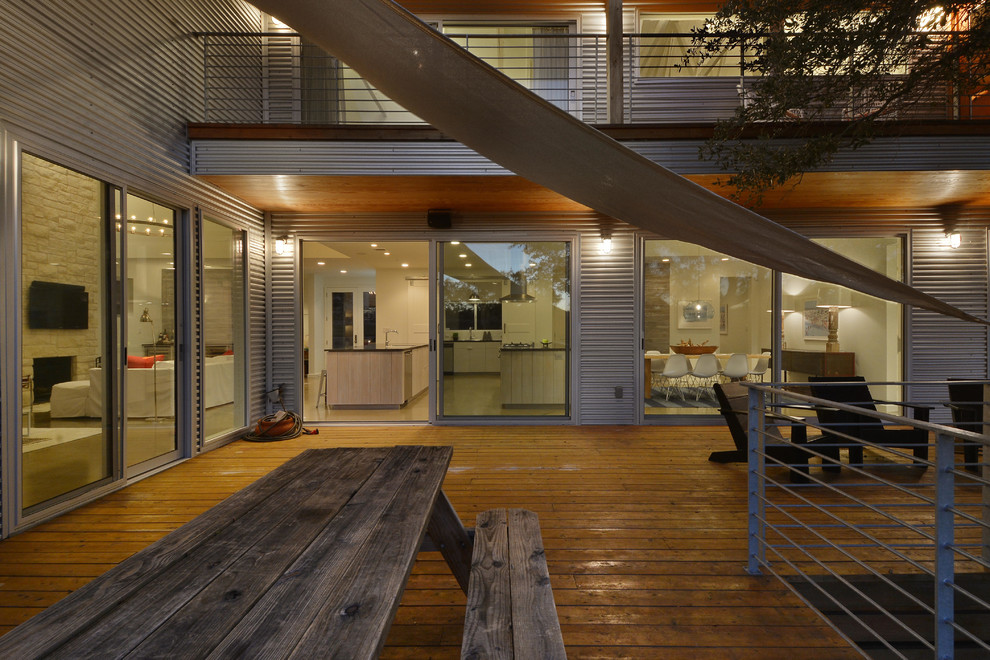 This is an example of a large urban back terrace in Austin with a roof extension.