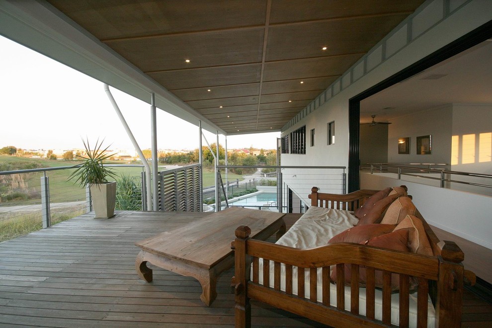 Cette photo montre une grande terrasse latérale tendance avec une extension de toiture.