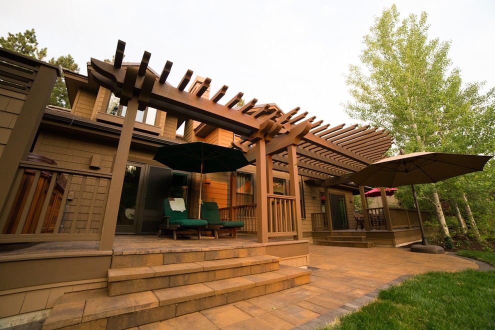 Mid-sized arts and crafts backyard deck photo in Portland with a pergola