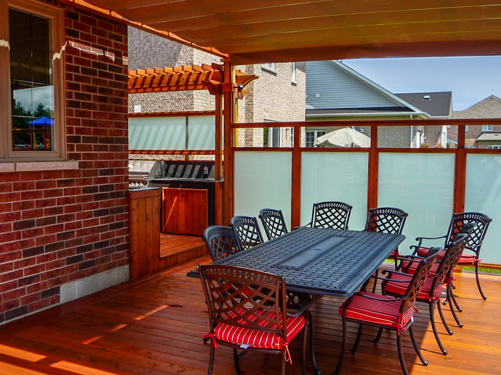 Ejemplo de terraza clásica de tamaño medio en patio trasero con cocina exterior y pérgola