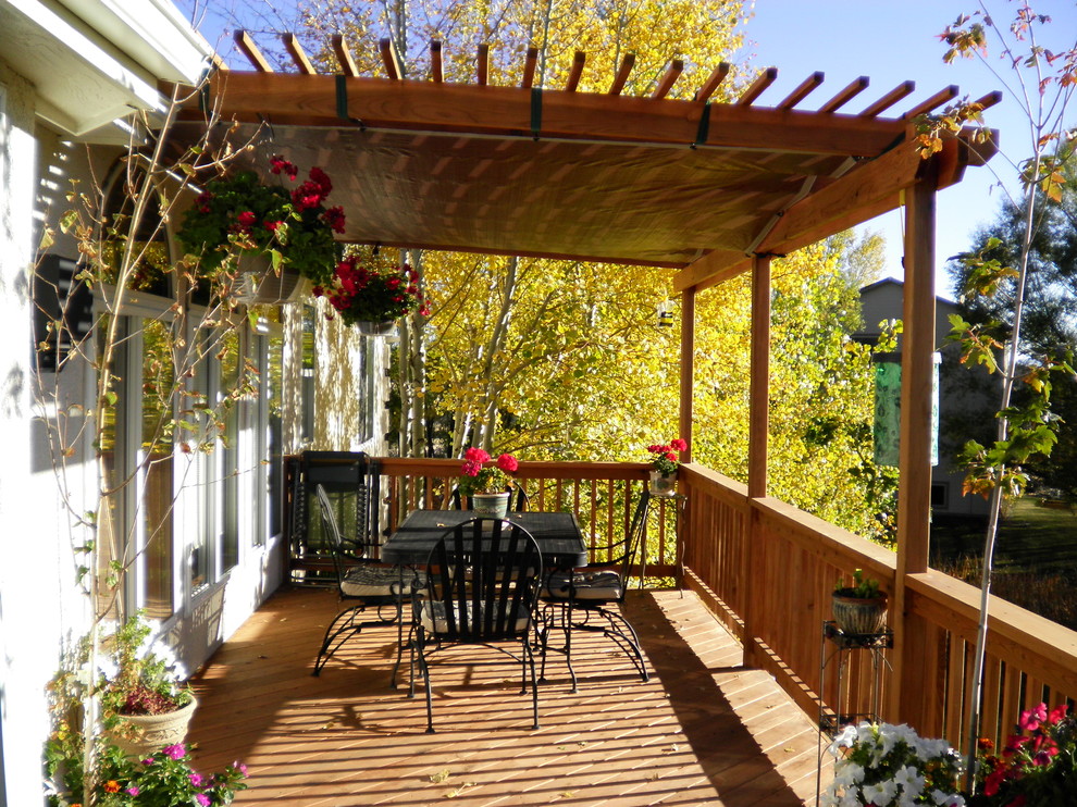 Imagen de terraza tradicional de tamaño medio en patio trasero con pérgola
