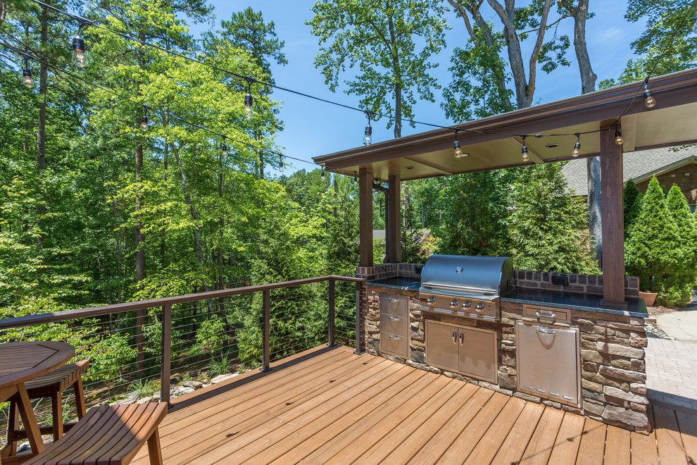Réalisation d'une terrasse arrière design de taille moyenne avec une cuisine d'été et une extension de toiture.