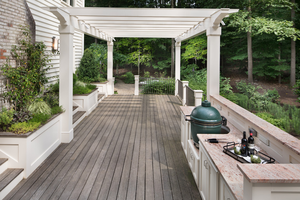 Foto de terraza tradicional renovada grande en patio trasero con cocina exterior y pérgola