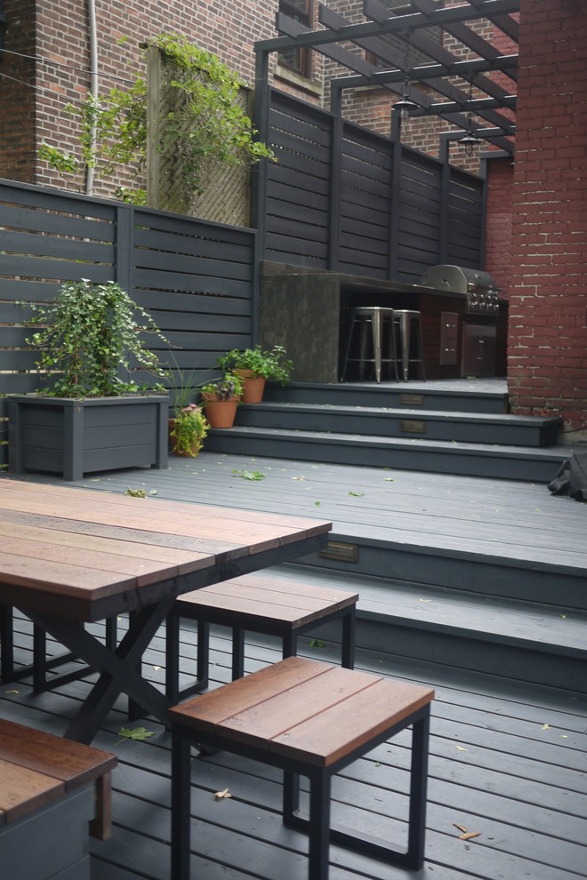 Outdoor kitchen deck - mid-sized contemporary backyard outdoor kitchen deck idea in Montreal with a pergola