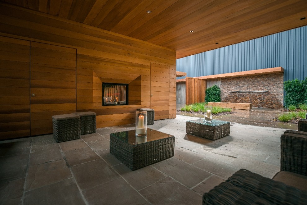Esempio di un ampio patio o portico minimalista dietro casa con un tetto a sbalzo