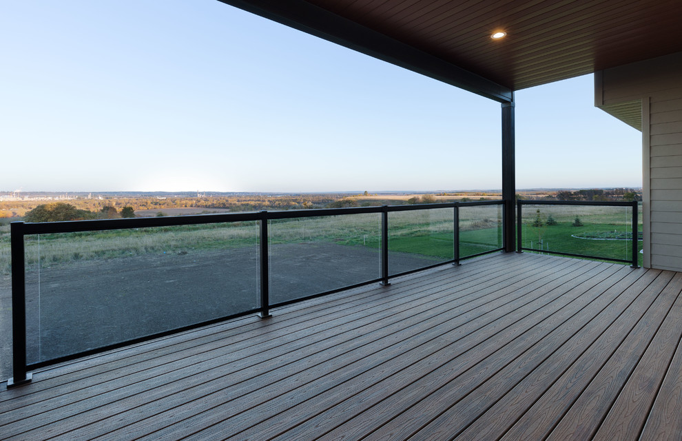 Réalisation d'une terrasse arrière design de taille moyenne avec une extension de toiture.