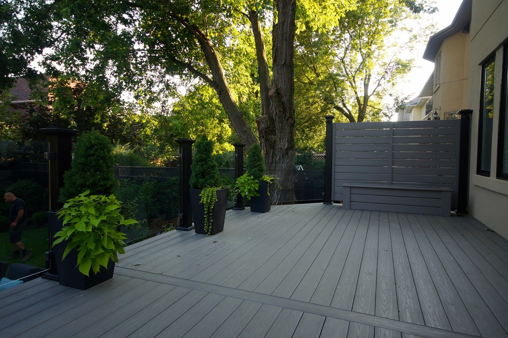 Example of a large minimalist backyard deck design in Toronto with no cover
