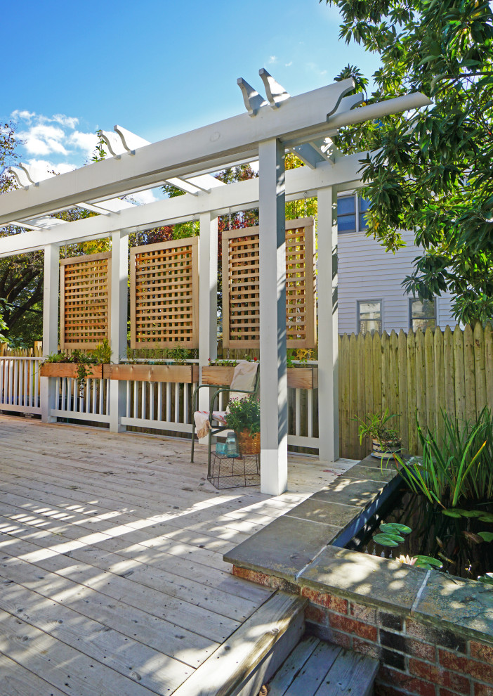 Modelo de terraza planta baja tradicional renovada de tamaño medio en patio trasero con privacidad, pérgola y barandilla de varios materiales