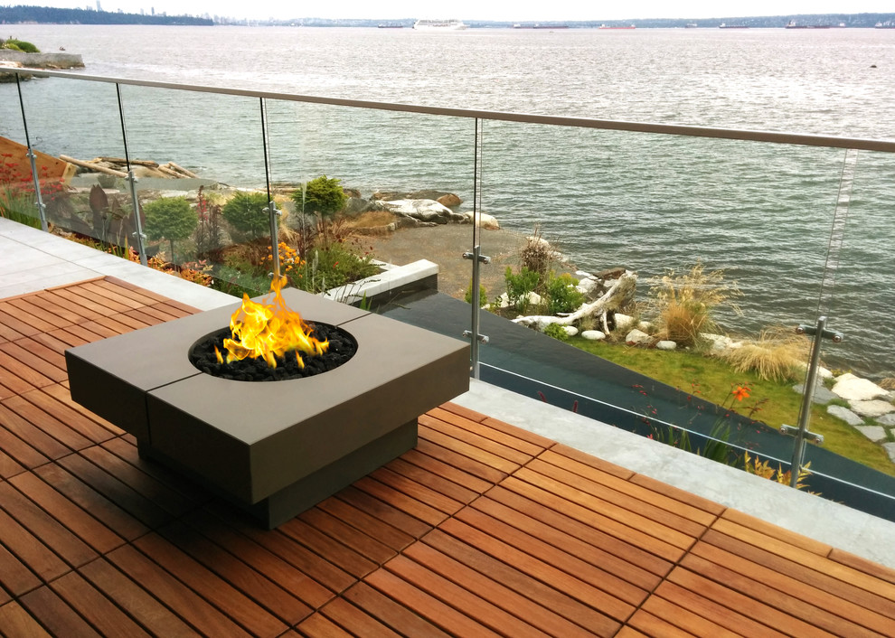 Example of a transitional backyard patio design in Vancouver with a fire pit