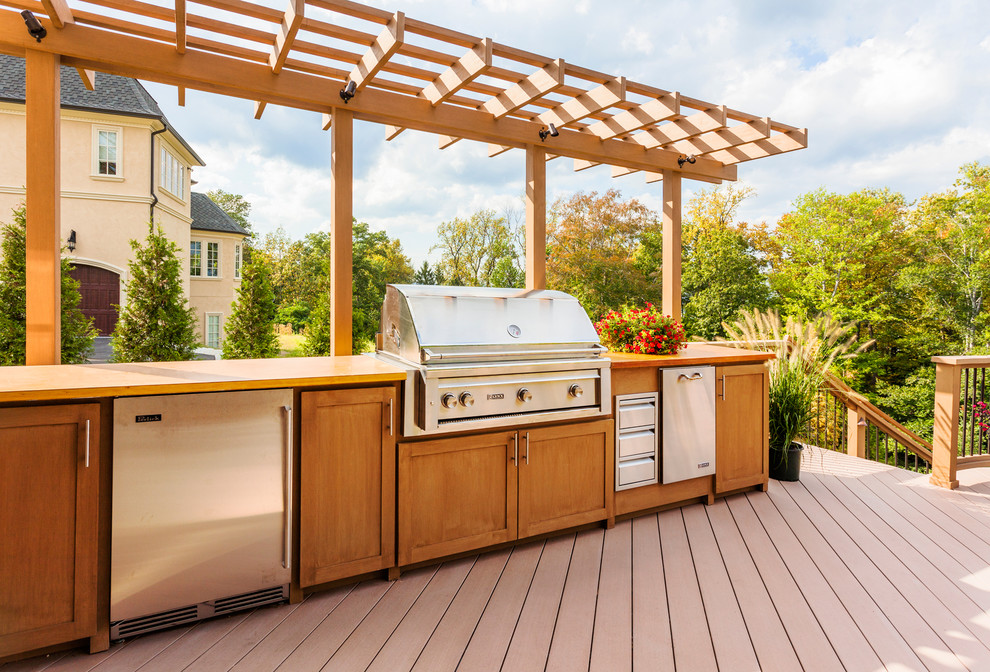 Imagen de terraza clásica grande en patio trasero con cocina exterior y pérgola