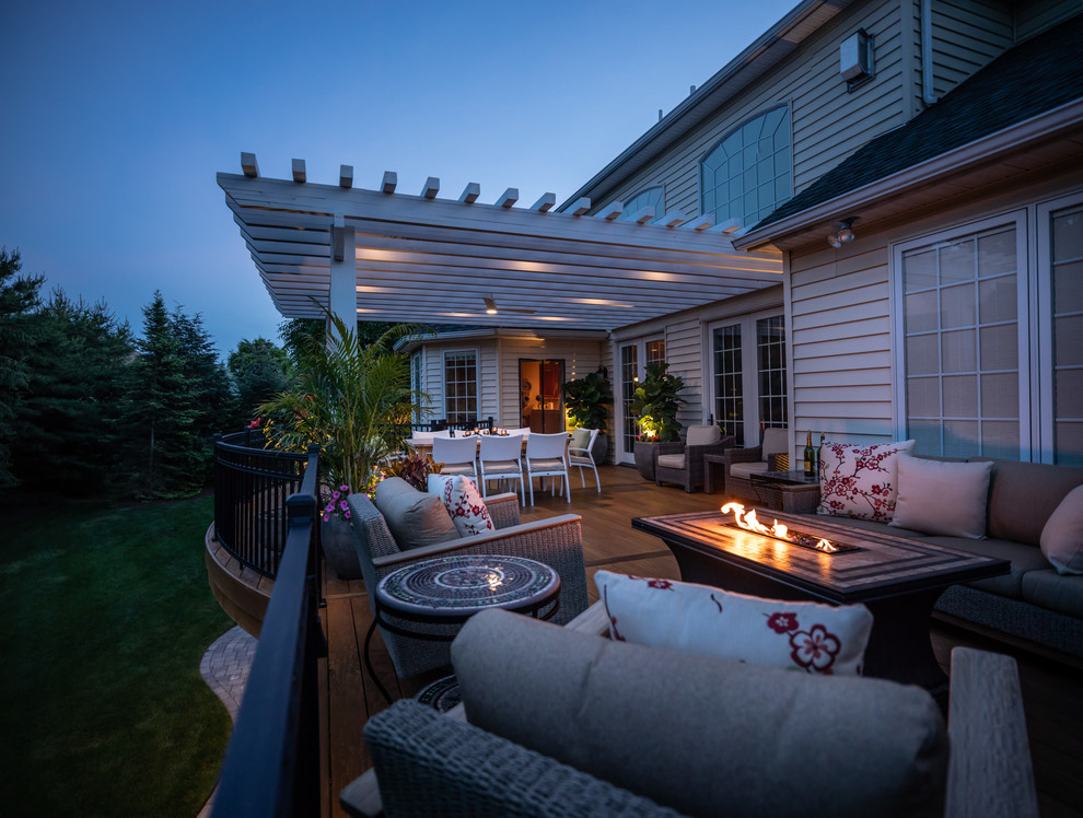 Example of a mid-sized tuscan backyard deck design in Philadelphia with a pergola