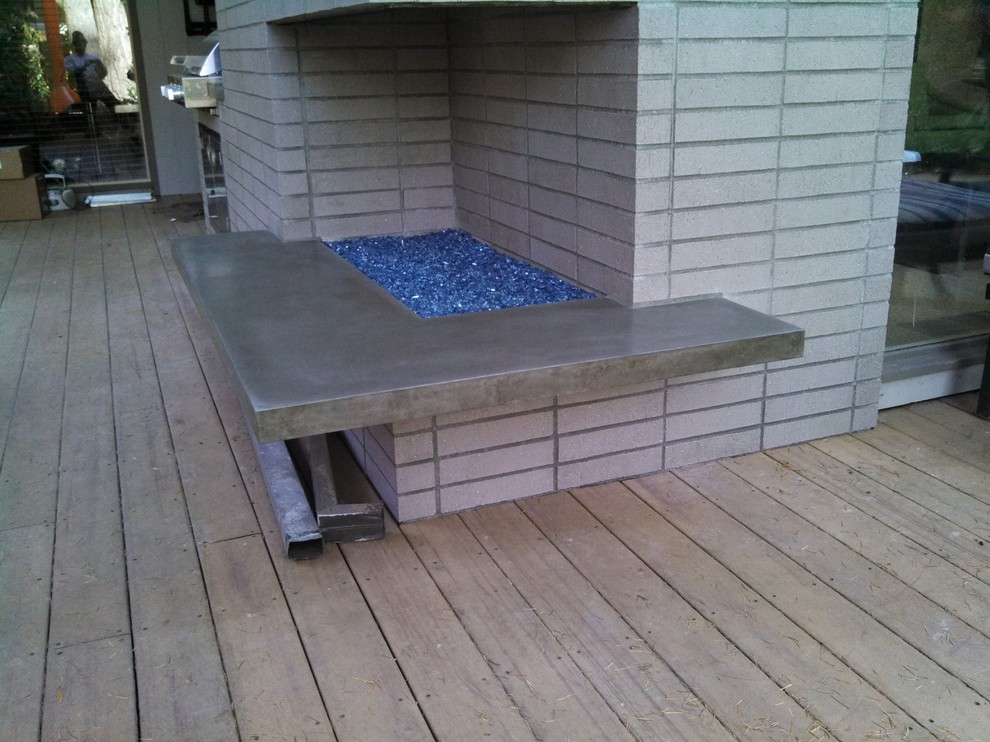 Immagine di una terrazza minimalista di medie dimensioni e dietro casa con un focolare