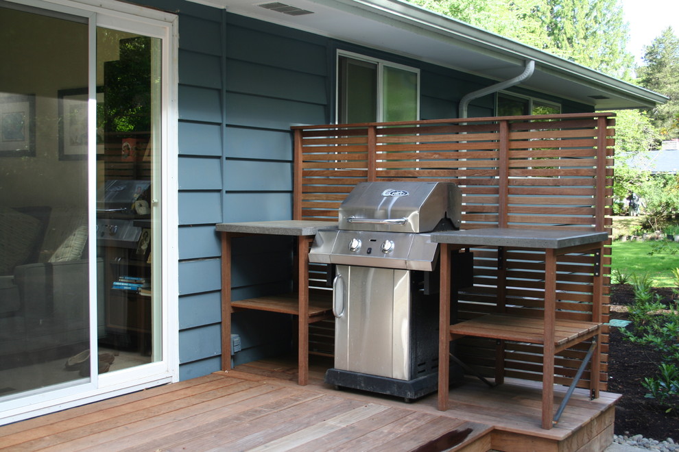 Réalisation d'une terrasse arrière design avec une cuisine d'été et aucune couverture.