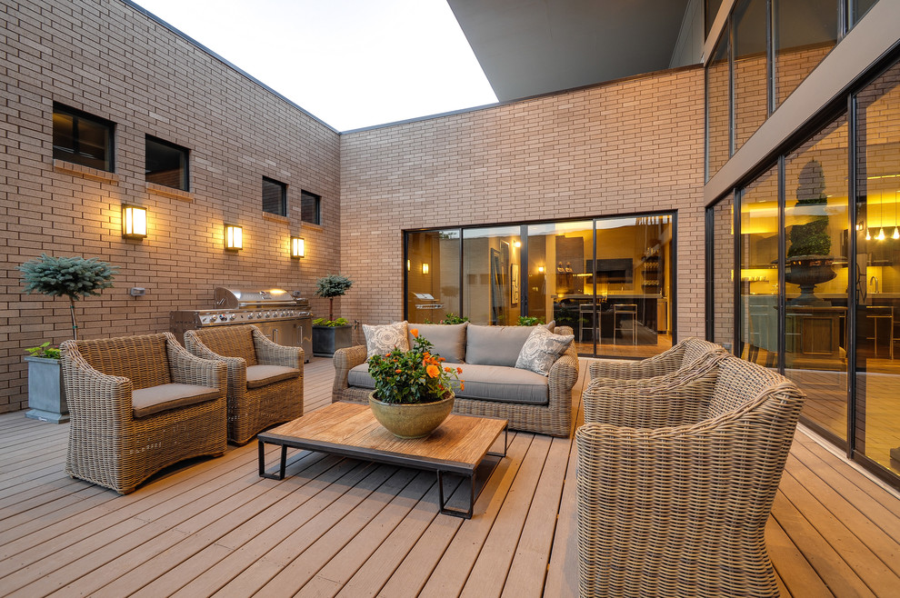 Inspiration for a mid-sized modern backyard deck remodel in Dallas with a roof extension