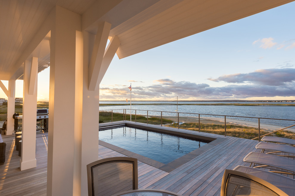 Cette photo montre une terrasse arrière bord de mer de taille moyenne avec une cuisine d'été et une extension de toiture.