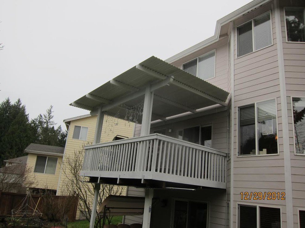 Cette image montre une petite terrasse arrière traditionnelle avec une extension de toiture.