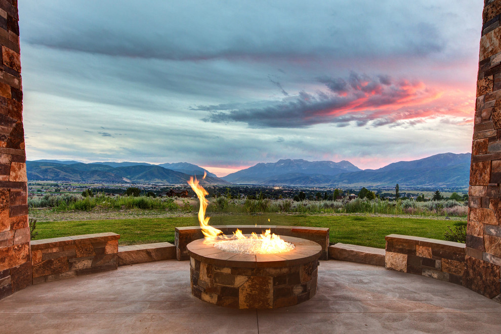 Inspiration for a large rustic side yard concrete patio remodel in Salt Lake City with a fire pit and a roof extension