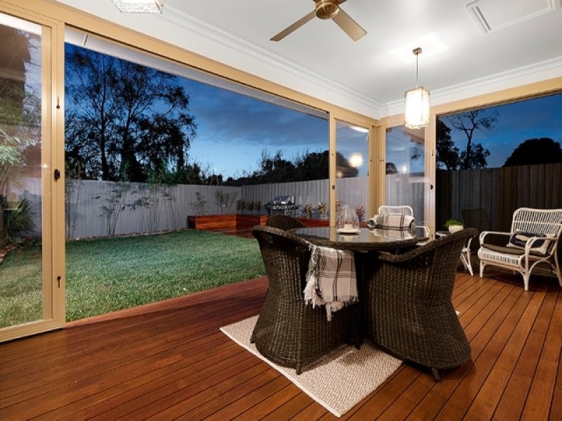 Example of a small trendy backyard deck design in Melbourne with a roof extension
