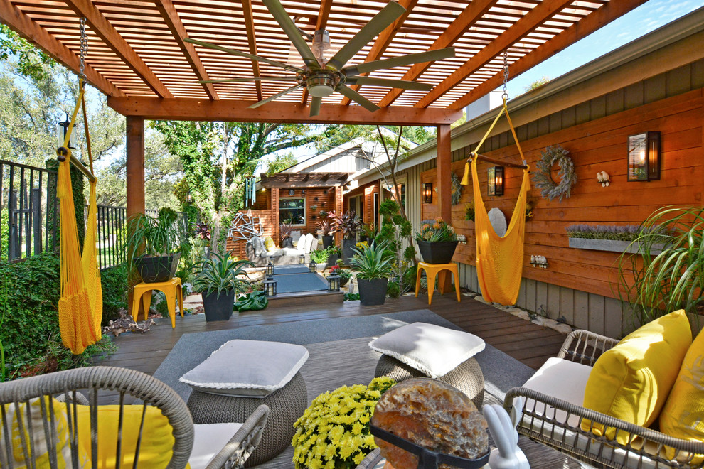 Photo of a large world-inspired back terrace in Austin with a potted garden and a pergola.