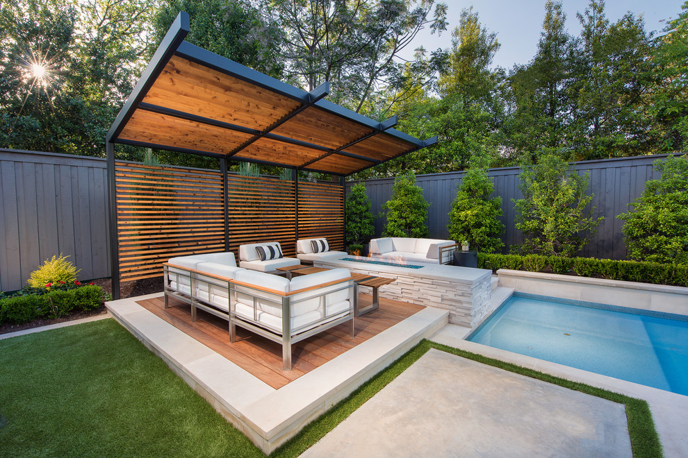 Exemple d'une terrasse arrière chic avec un foyer extérieur et une pergola.