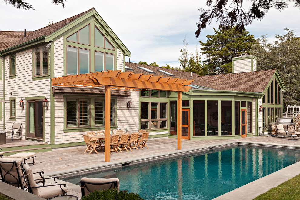 This is an example of a large beach style back terrace in Toronto with a pergola.