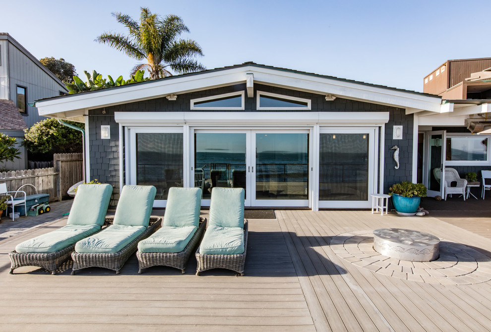Inspiration pour une terrasse arrière marine avec un foyer extérieur.