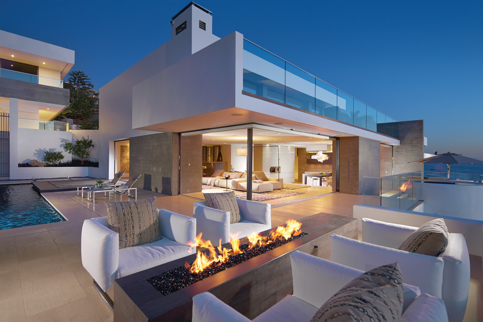 Große Moderne Terrasse hinter dem Haus mit Feuerstelle in Orange County