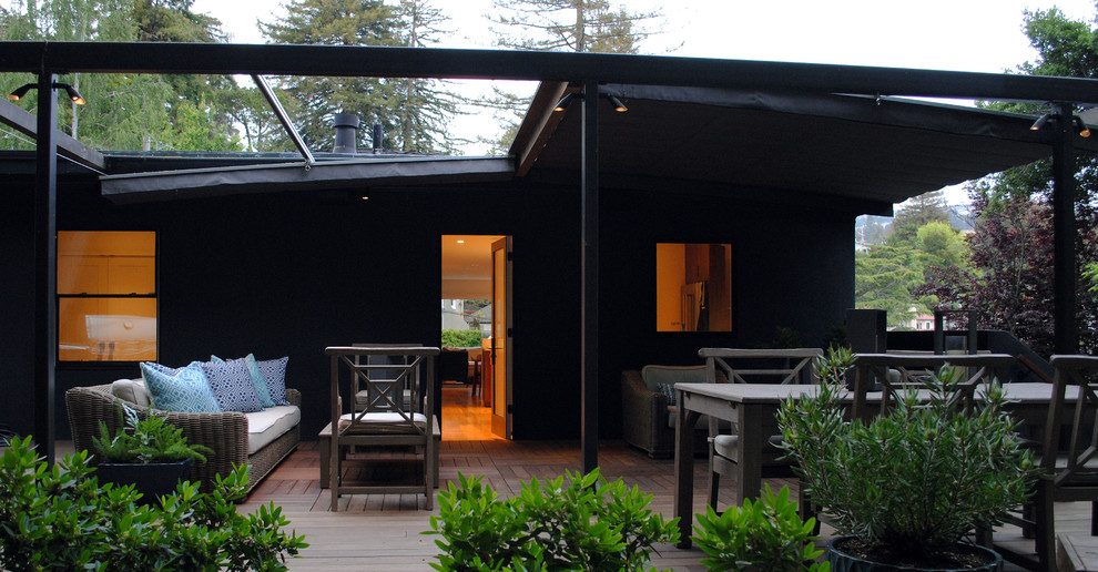 Immagine di una terrazza moderna di medie dimensioni e dietro casa con un parasole
