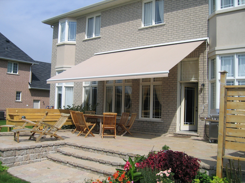 Esempio di una terrazza classica di medie dimensioni e dietro casa con un parasole