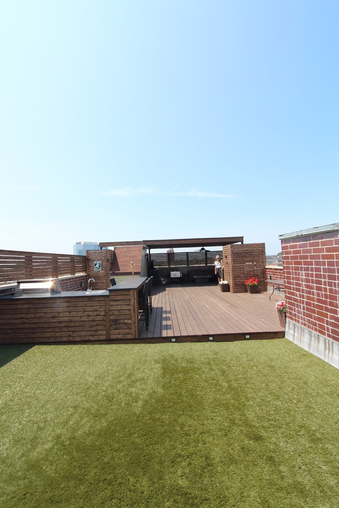Cette image montre une terrasse design avec une cuisine d'été et une pergola.