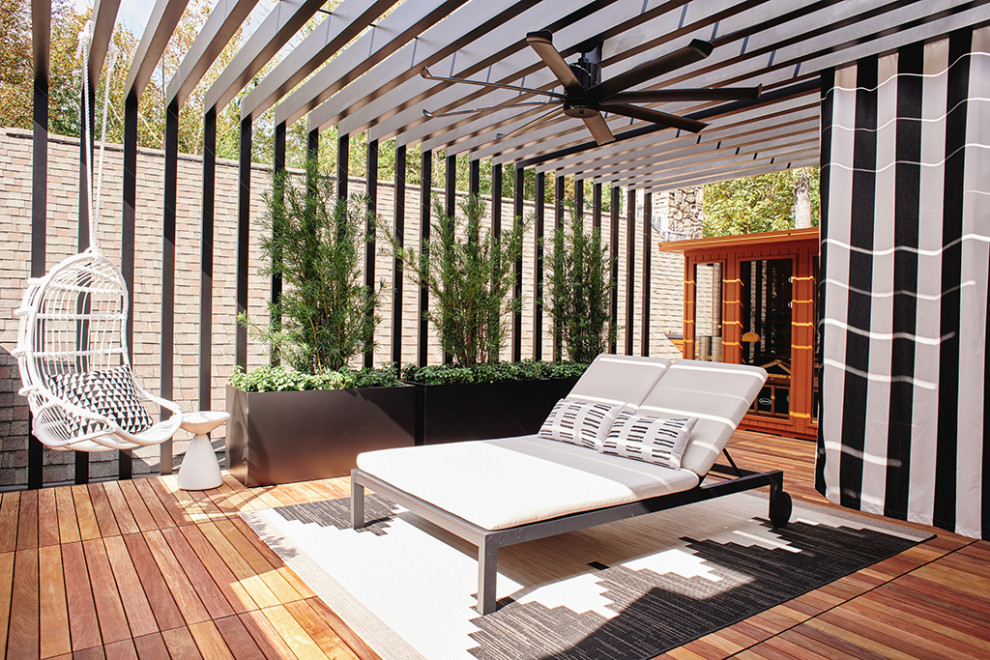 Aménagement d'un toit terrasse au premier étage moderne de taille moyenne avec des solutions pour vis-à-vis, une pergola et un garde-corps en métal.