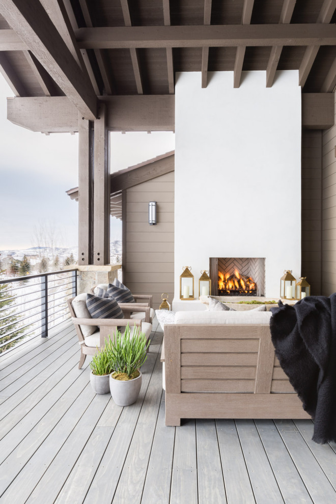 Cette image montre une terrasse chalet avec une cheminée et une extension de toiture.