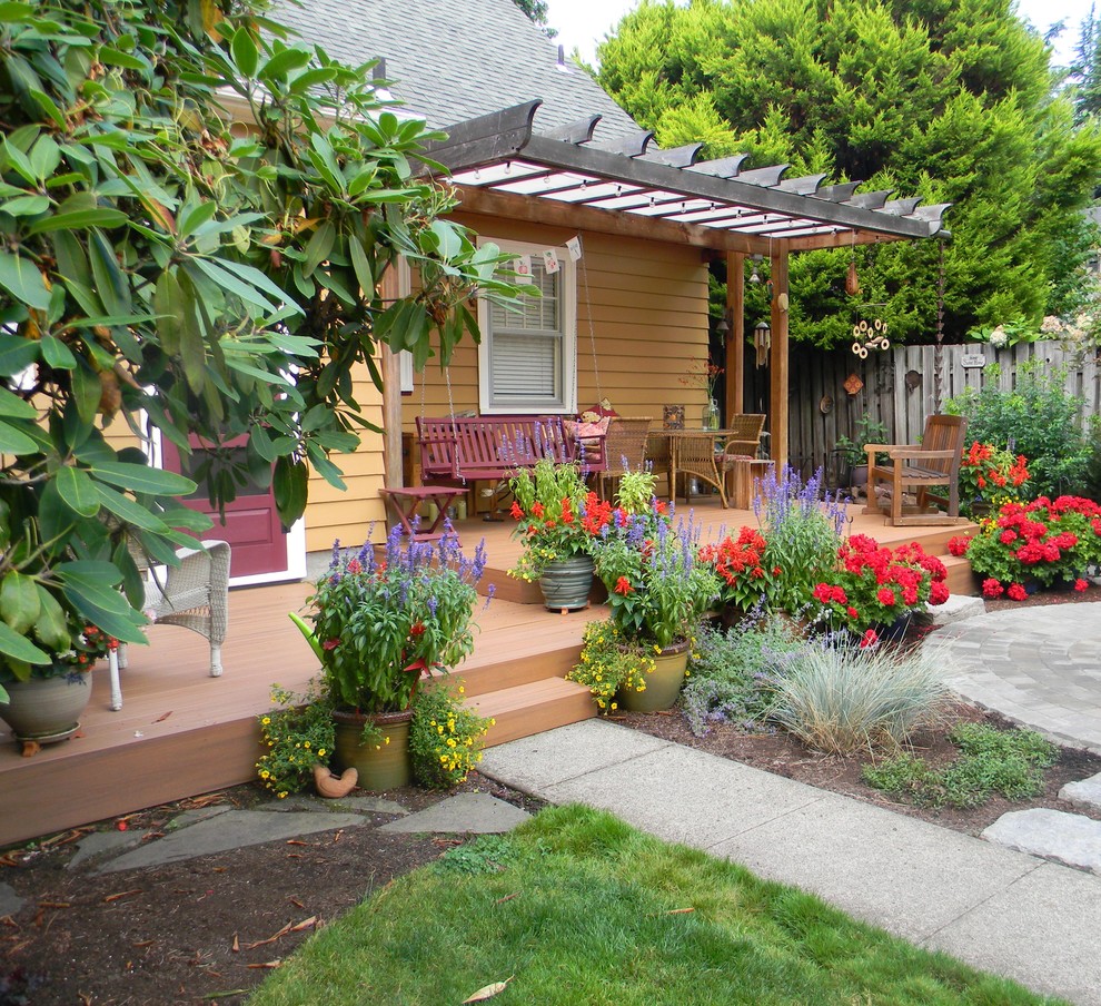 Example of a small arts and crafts backyard deck design in Portland with a pergola