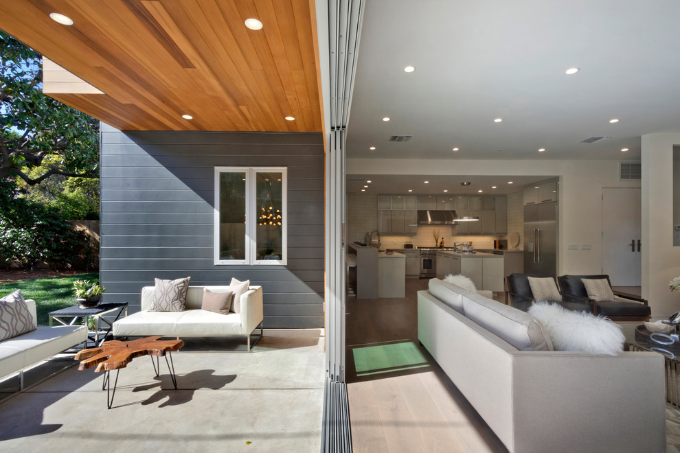 Example of a small minimalist backyard deck design in Los Angeles with a roof extension