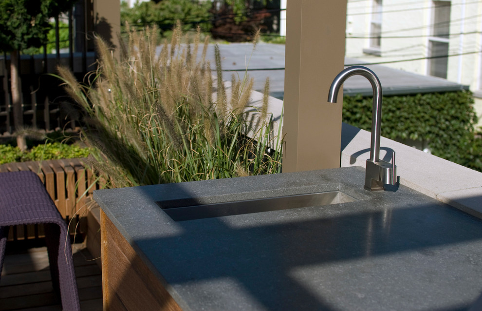 Cette photo montre une terrasse moderne avec une cuisine d'été et un auvent.