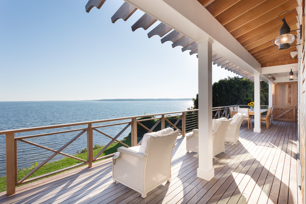 Deck - large coastal backyard deck idea in New York with a roof extension