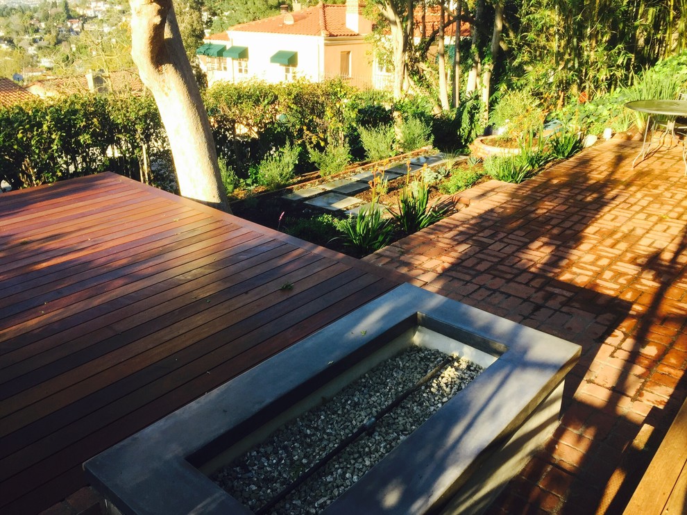 ロサンゼルスにある広いサンタフェスタイルのおしゃれな裏庭のデッキ (ファイヤーピット、日よけなし) の写真
