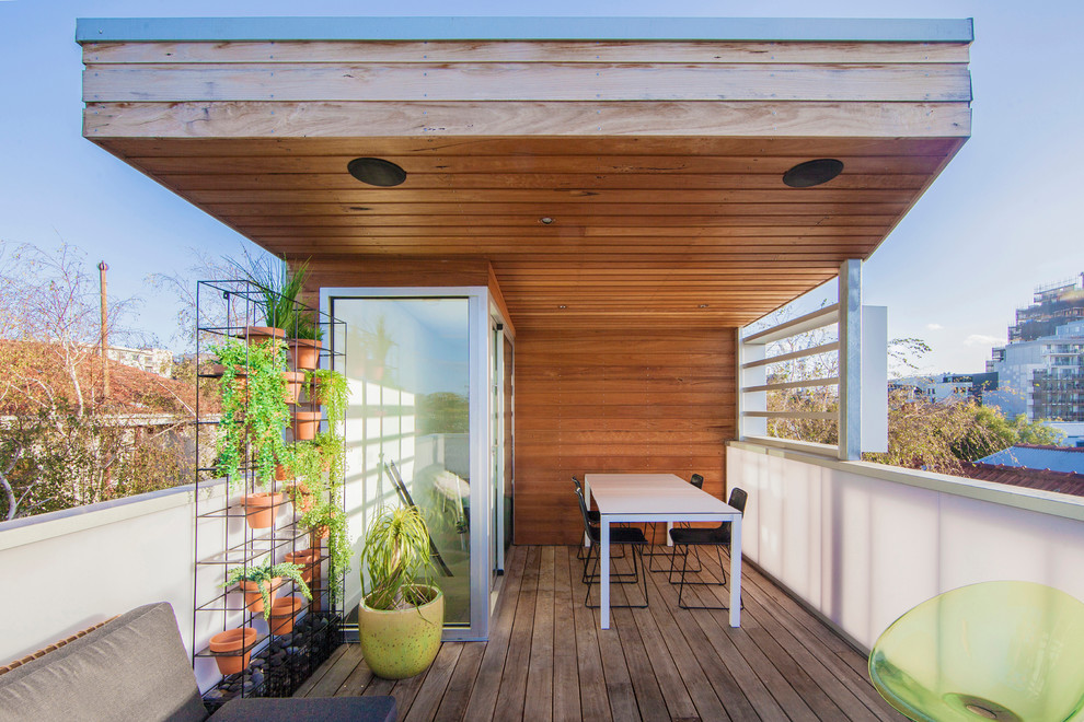 Idee per una piccola terrazza minimal sul tetto e sul tetto con un giardino in vaso e un parasole