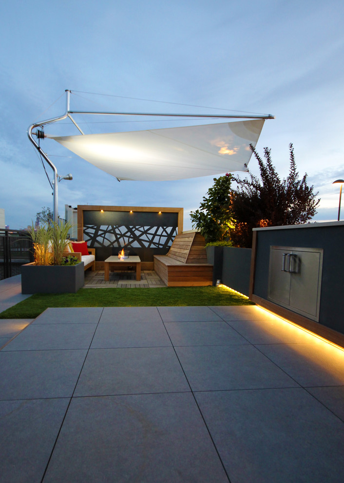 Cette image montre une terrasse minimaliste avec une cuisine d'été et un auvent.
