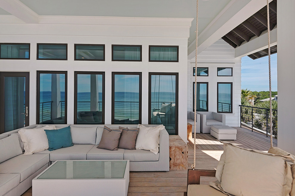 Large beach style deck photo in Miami with a roof extension