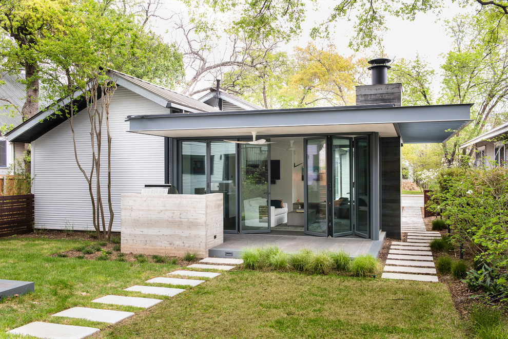 Cette photo montre une terrasse arrière de taille moyenne avec une cuisine d'été et une extension de toiture.