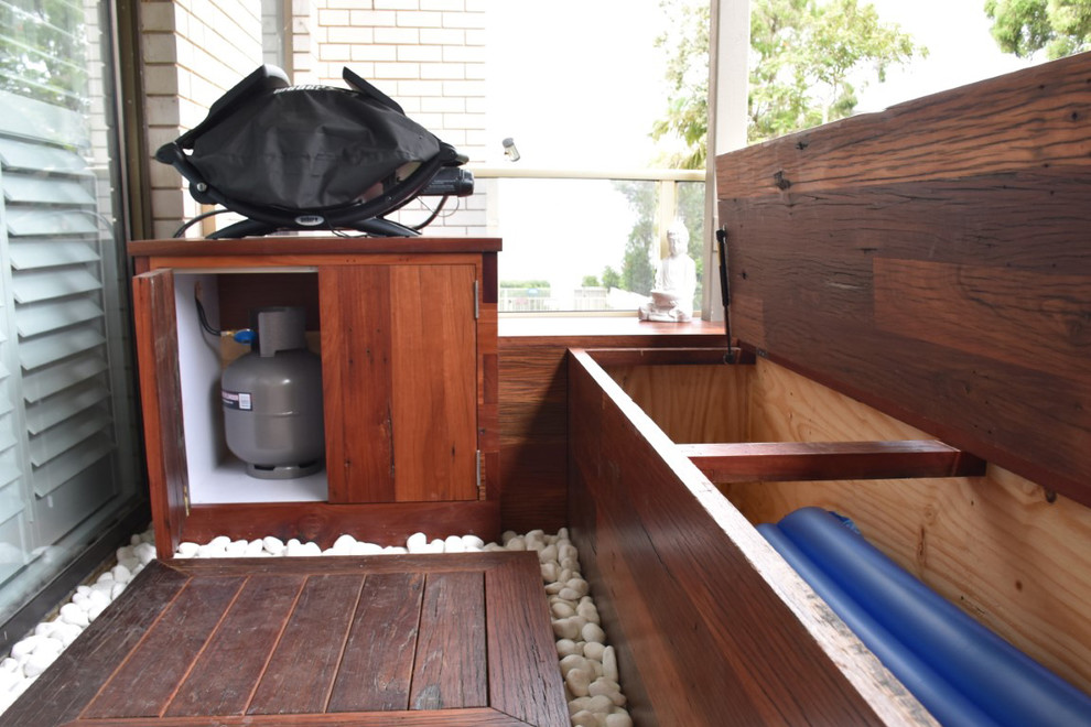 Réalisation d'une petite terrasse latérale design avec un point d'eau et une extension de toiture.